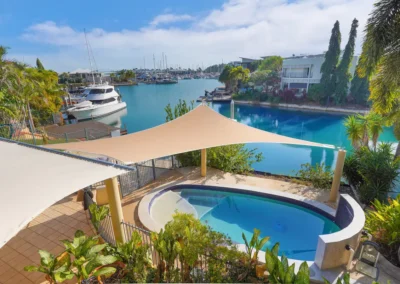 villa marina darwin air bnb vacation rental home backyard with infinity pool looking out onto cullen bay marina with pontoon